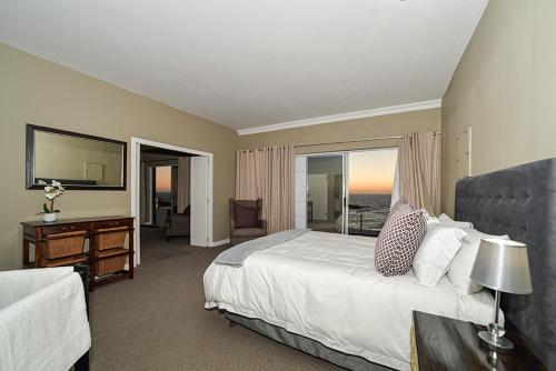 a bedroom with a bed and a desk and a television at Atlantica in Yzerfontein