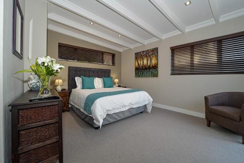 a bedroom with a bed and a chair at Atlantica in Yzerfontein