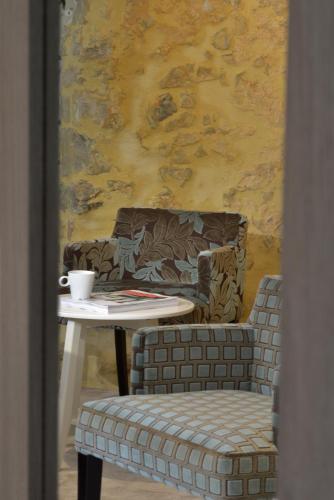 a table and a chair with a coffee cup on it at La Maison de Mathilde in Bayeux