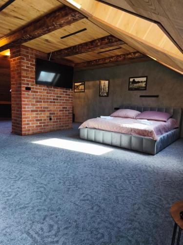 a bedroom with a bed and a brick wall at Hotel U Valdické brány in Jičín