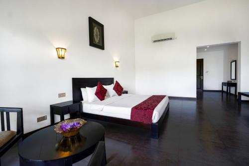 a hotel room with a bed and a table at Grand Tamarind Lake in Kataragama