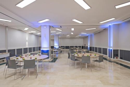 a dining hall with tables and chairs and blue lighting at INNSiDE by Meliá Barcelona Apolo in Barcelona