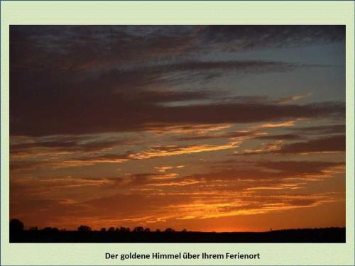 a sunset in the sky with clouds at Grüne Idylle in Borrentin