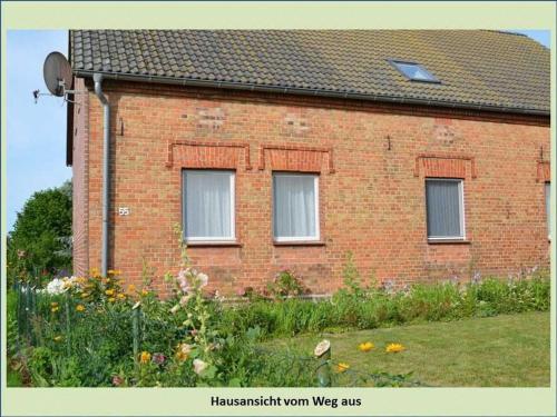 a brick house with three windows in a yard at Grüne Idylle in Borrentin