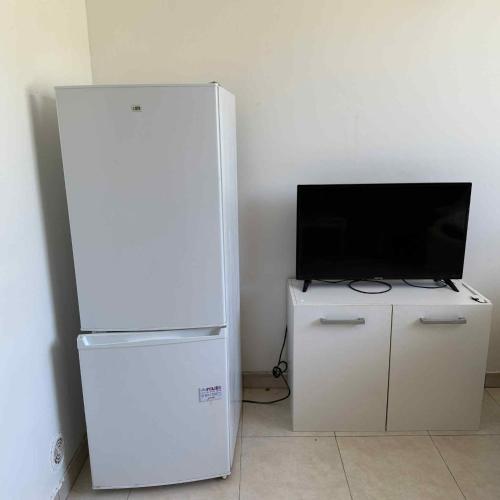 un frigorifero bianco e una televisione in una stanza di Studio Corbeil Essonnes a Corbeil-Essonnes