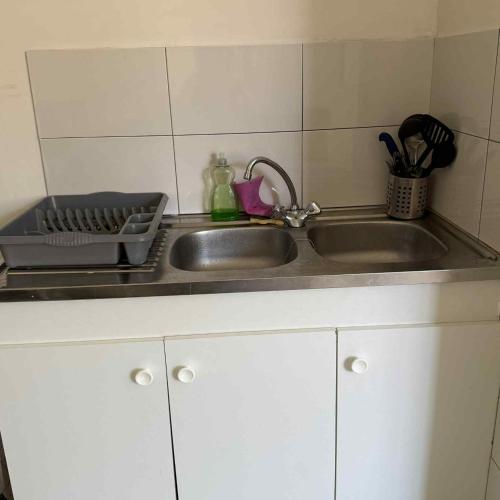 un lavello da cucina con accanto uno scolapiatti di Studio Corbeil Essonnes a Corbeil-Essonnes
