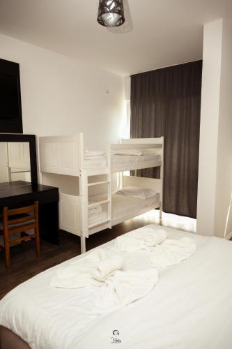 a bedroom with a white bunk bed and a desk at Hotel & Restaurant Frida in Gjakove