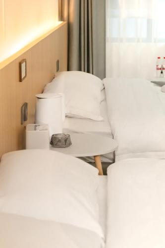 three beds in a room with white pillows at Yunzhan hotel in Dali