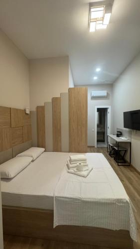 a bedroom with a large bed and a television at Deribas Apartments in Odesa