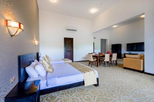 a hotel room with a bed and a living room at Grand Tamarind Lake in Kataragama