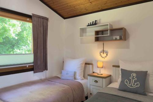 Un dormitorio pequeño con dos camas y una ventana. en Simi, en Simonsberg