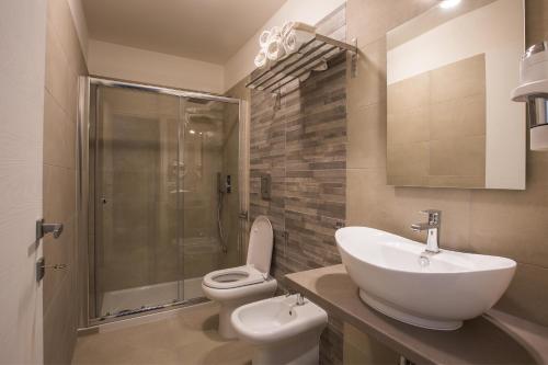 een badkamer met een wastafel, een toilet en een douche bij B&B In Centro in Vieste