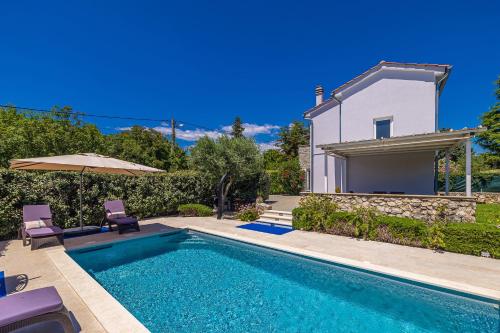 a villa with a swimming pool and a house at Holiday house CIRIK in Kras