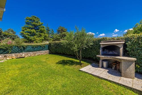 a garden with a stone oven in the grass at Holiday house CIRIK in Kras