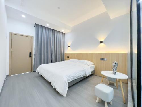 a bedroom with a large white bed and a table at Yunzhan hotel in Dali