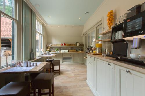 a large kitchen with a table and a counter top at Hotel Erve Hulsbeek in Oldenzaal