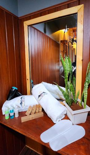 a table with towels and a potted plant on it at Rainbow Sky Cottage in Ella