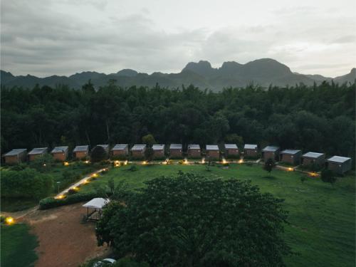 a group of buildings in a field with lights at Chong khaep aingkwai resort Saiyok in Sai Yok