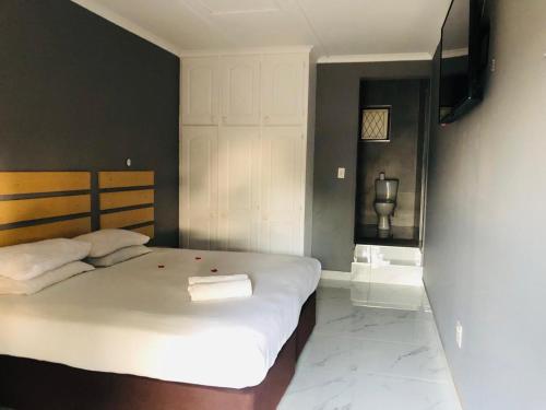 a bedroom with a large white bed and a television at Zakuza Shelly Sea View Lodge in Margate