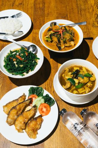 a table with several plates of food on it at Chong khaep aingkwai resort Saiyok in Sai Yok