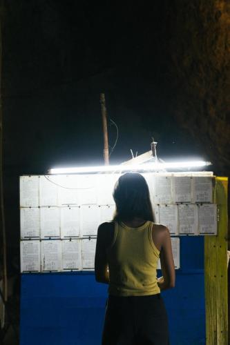 a woman standing in front of a wall with lights at Chong khaep aingkwai resort Saiyok in Sai Yok