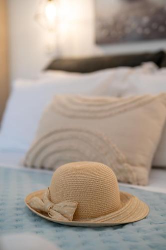 a straw hat sitting on top of a bed at SKYROS AVRA Residences in Skiros