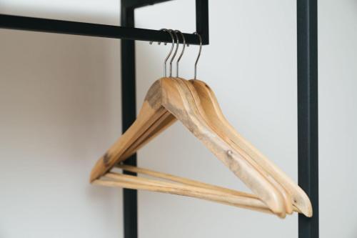 a pair of wooden hangers hanging on a black rack at Chong khaep aingkwai resort Saiyok in Sai Yok