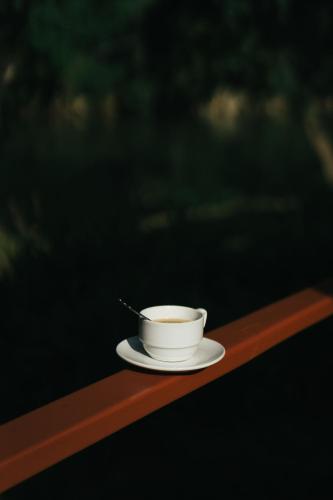 a cup of coffee sitting on a wooden table at Chong khaep aingkwai resort Saiyok in Sai Yok