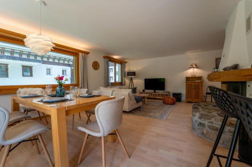 a living room with a wooden table and chairs at Exclusive Glacier View Apartment 1-4 Pers in Klosters