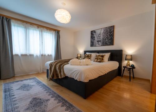 a bedroom with a bed and a large window at Exclusive Glacier View Apartment 1-4 Pers in Klosters