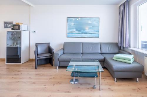 a living room with a couch and a table at Haus Atlantic, FeWo 305 in Döse