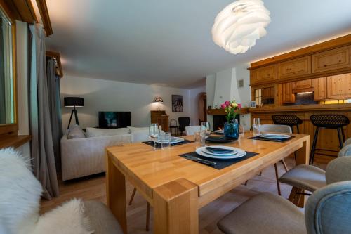 a kitchen and living room with a wooden table at Exclusive Glacier View Apartment 1-4 Pers in Klosters