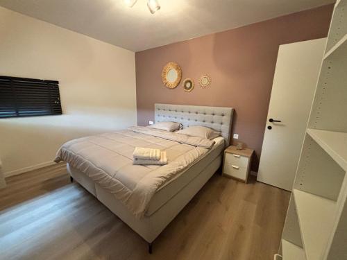 a bedroom with a bed and a clock on the wall at Home Terboekt in Genk