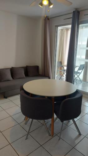 un salon avec une table, des chaises et un canapé dans l'établissement Vacances à la mer, à La Grande Motte
