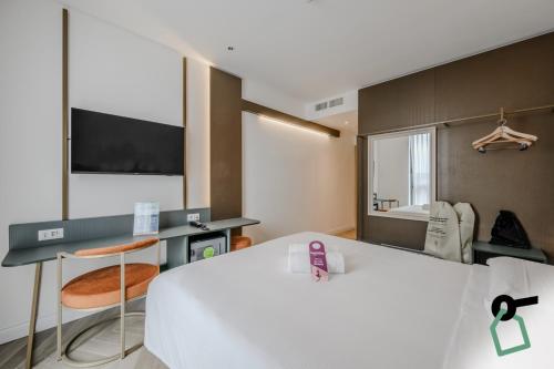 a hotel room with a large white bed and a mirror at Hotiday Venezia Tronchetto in Venice