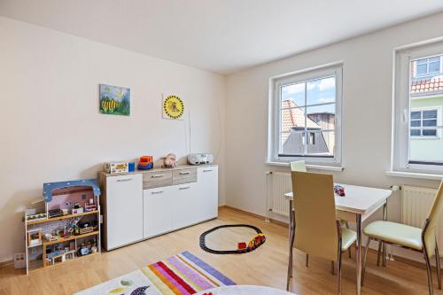 a kitchen with a table and a white refrigerator at Ferienwohnung "FLORI's PONYHOF" in Kröpelin