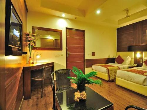a hotel room with a room with two beds and a table at Hotel Krishna Land in New Delhi