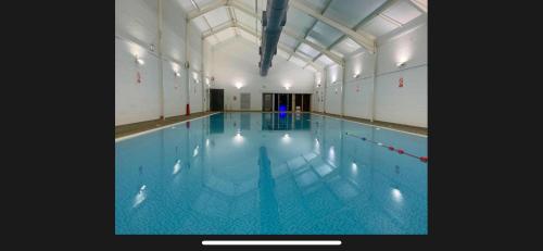 a large swimming pool in a building at Sunrise Cottage with on-site swimming and sauna in Filey