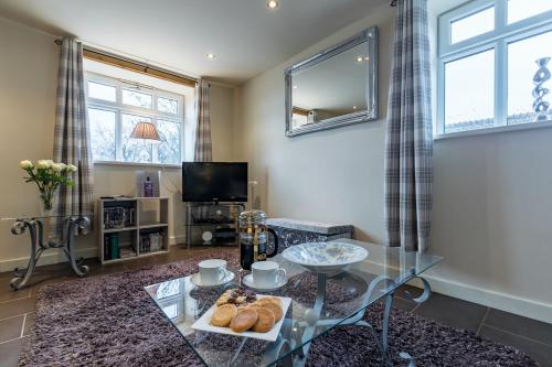 a living room with a glass table and a television at The Barn at Brambles Farm in Bradnop