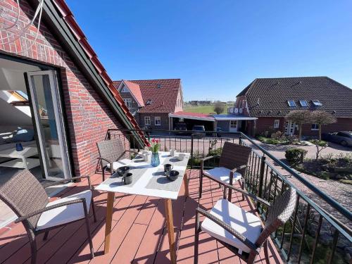 a patio with a table and chairs on a balcony at Trabbi-Haus in Harlesiel