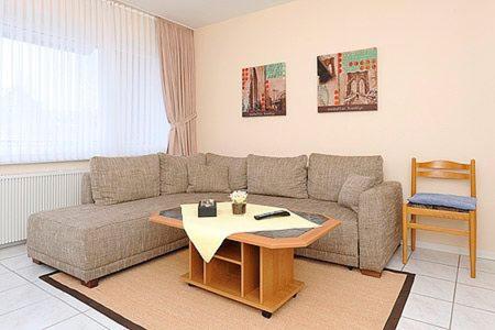 a living room with a couch and a table at Ferienwohnungen Alter Sielweg Wohnung 12 in Bensersiel