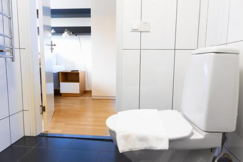 une salle de bain blanche avec toilettes et lavabo dans l'établissement Hotel Apartments Lund, à Lund