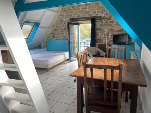 a dining room with a table and a staircase at GITE Le BELLEVUE 2-4 pers, piscine, billiard et baby-foot in Sainte-Hélène