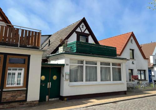 a large white house with a green door at Ferienwohnungen Alexandrinenstraße in Warnemünde in Warnemünde