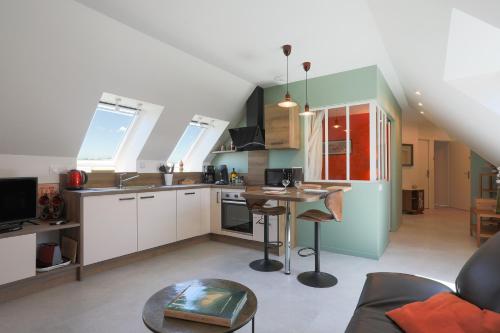 - une cuisine avec une table au milieu d'une pièce dans l'établissement Gîte Kerli cosy 2kms plage, à Trévou-Tréguignec