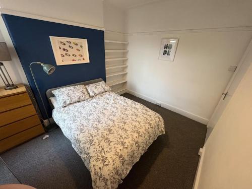 a small bedroom with a bed and a lamp at Room in Cardiff City near Hospital in Cardiff