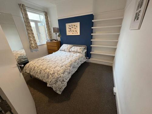 a bedroom with two beds and a blue wall at Room in Cardiff City near Hospital in Cardiff