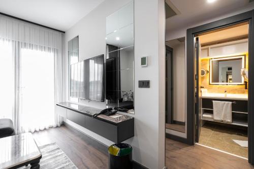 Un baño con lavabo y un espejo grande. en Best Western Plus Trabzon, en Trabzon