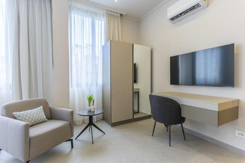 a room with a desk and a chair and a tv at CityZen - Boutique Studios in Achrafieh in Beirut