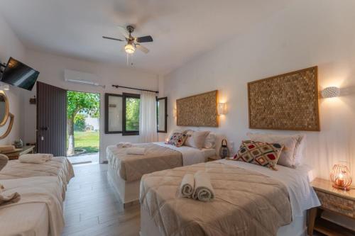 pokój hotelowy z 3 łóżkami i telewizorem w obiekcie SKYROS AVRA Residences w mieście Skiros
